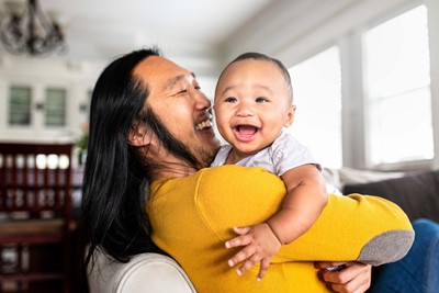 Oriental Dad And Child Lores, A father smiling and holding a laughing baby, representing the joy of fatherhood supported by SCCFF's Midlands Gives Day 2024 fundraising campaign